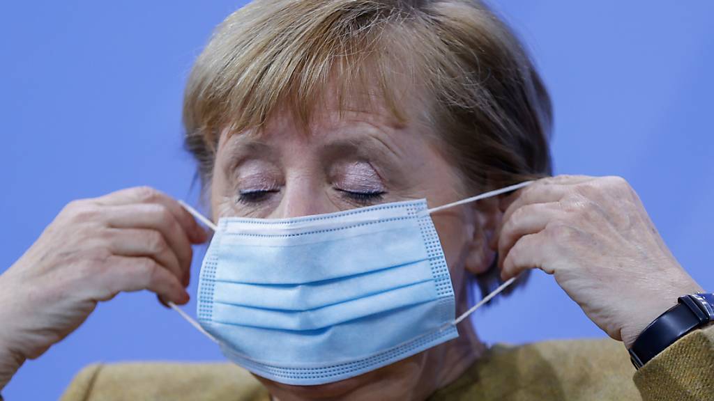 Bundeskanzlerin Angela Merkel (CDU) setzt ihre Gesichtsmaske nach ihrer Pressekonferenz auf. Foto: Odd Andersen/AFP/POOL/dpa