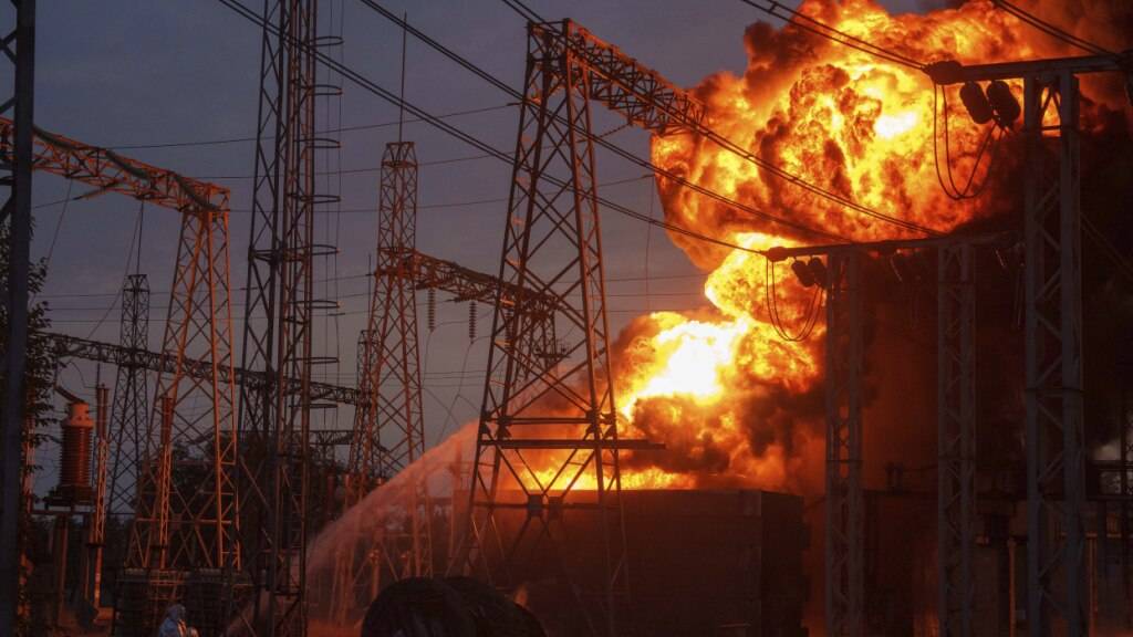 ARCHIV - Rettungskräfte löschen ein Feuer in einem brennenden Umspannwerk, das von einem russischen Angriff getroffen wurde, in der Region Dnipropetrowsk. Foto: Evgeniy Maloletka/AP/dpa