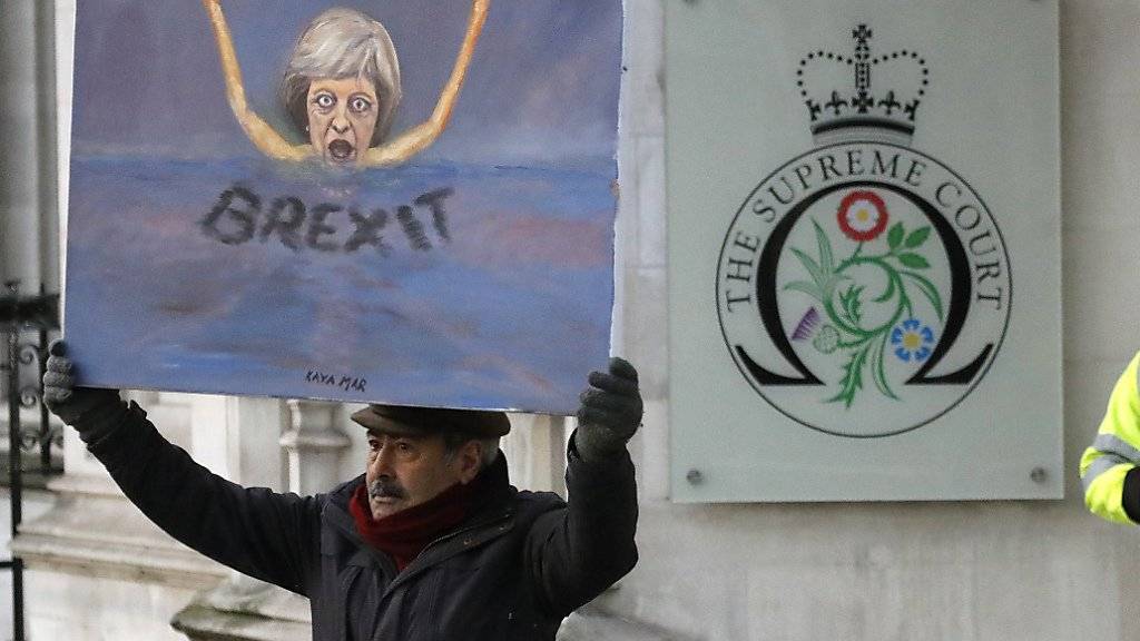 Ein Maler mit einem Bild von Premierministerin Theresa May vor dem Londoner Supreme Court: Dieser hat entschieden, dass das britische Parlament beim EU-Ausstieg mitreden muss.