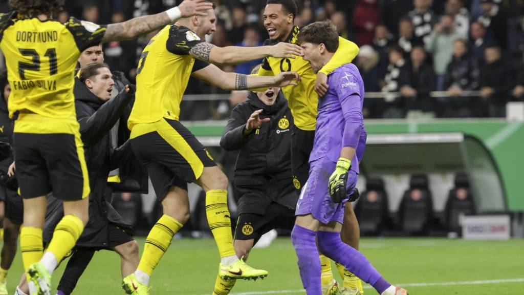Die BVB-Spieler fallen ihrem Goalie Gregor Kobel nach dem Penalty-Krimi um den Hals