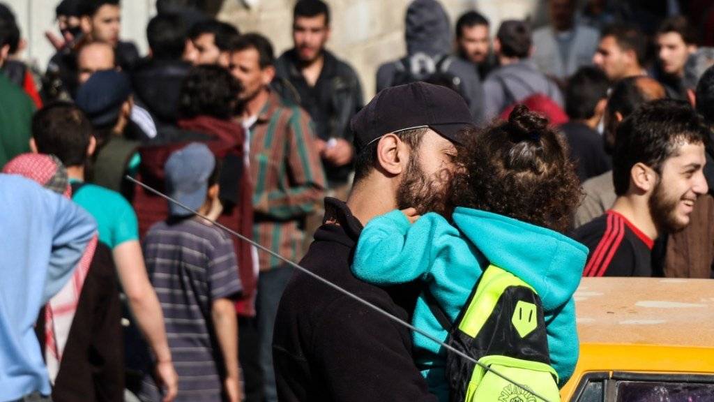 Rebellenkämpfer und ihre Familien versammelten sich vor der Evakuierung in Barseh, einem von der Regierung belagerten Vorort von Damaskus. Die UNO kritisiert die Evakuierungen als Vertreibung.