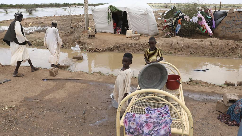 Zwei kleine sudanesische Jungen stehen vor ihrer provisorischen Unterkunft am Straßenrand, etwa 60km von der Hauptstadt entfernt. Sintflutartige Regenfälle haben Häuser und die Infrastruktur im ganzen Land verwüstet. Mehr als 50 000 Menschen sind nach Angaben der Vereinten Nationen betroffen. Foto: Marwan Ali/AP/dpa