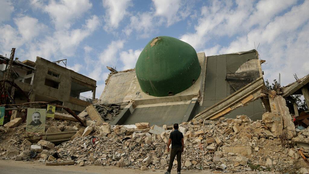 PRODUKTION - Ein Mann betrachtet die Kuppel einer zerstörten Moschee in dem südlibanesischen Dorf Aita al-Schaab. Foto: Marwan Naamani/dpa