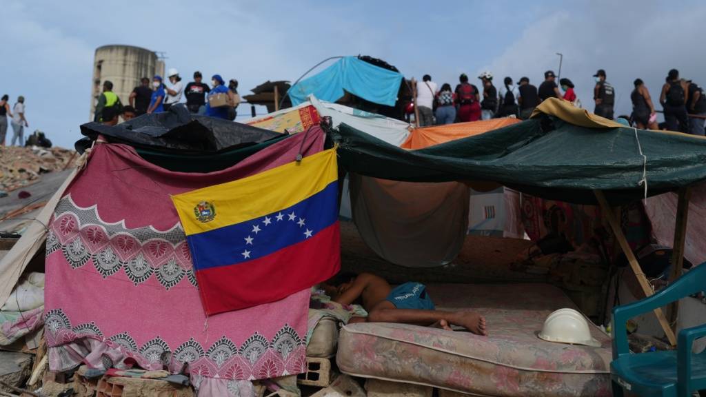 ARCHIV - Ein junger Mann schläft in einer Behausung, während Rettungskräfte nach den Erdbeben in La Guaira, Venezuela, weiter in den Trümmern suchen. Foto: Ariana Cubillos/AP/dpa