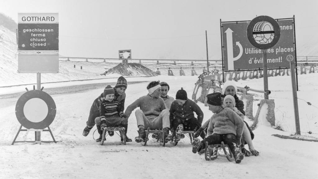 Kinder beim Schlitteln auf der gesperrten Gotthardstrasse bei Hospental im Kanton Uri, aufgenommen im Januar 1962. (Archivbild)