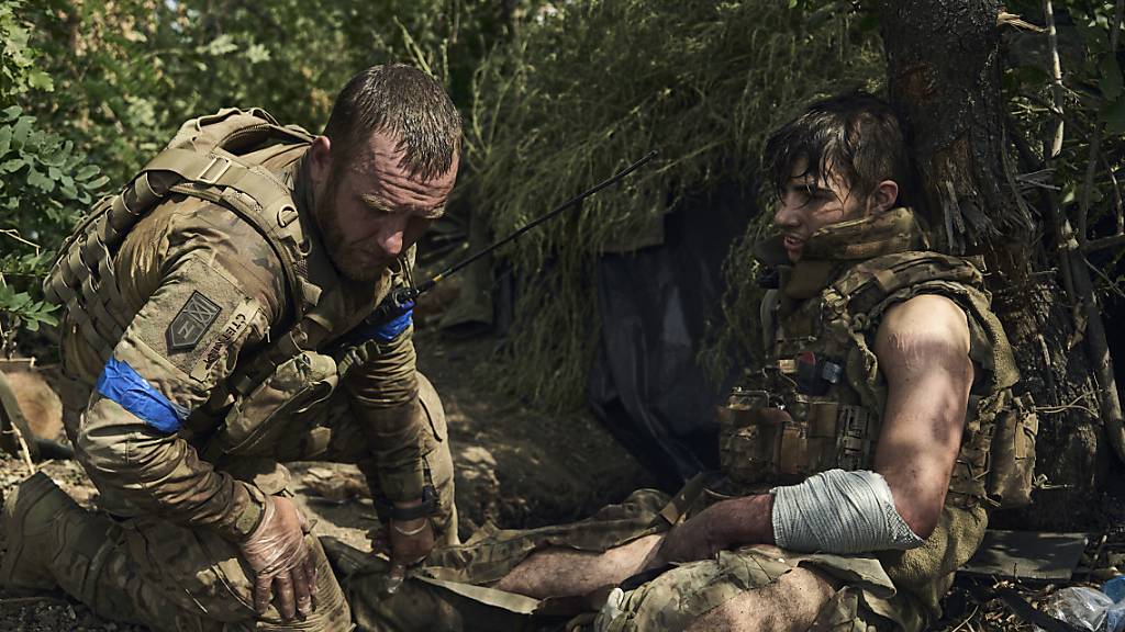 Ein ukrainischer Soldat leistet seinem verwundeten Kameraden erste Hilfe. Foto: LIBKOS/AP