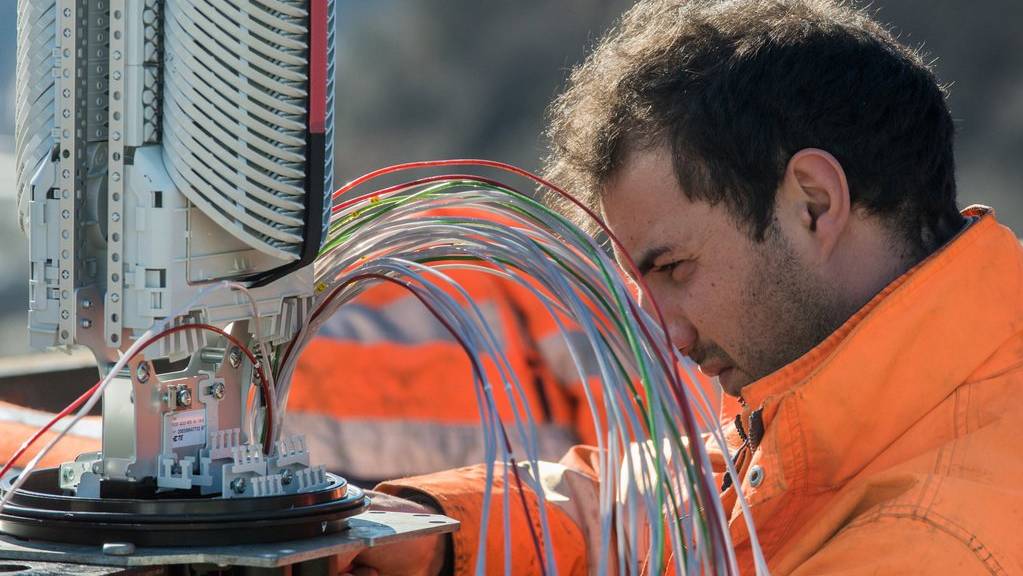 Ein Arbeiter montiert das Glasfasernetz, das private Haushalte mit schnellem Internet bedient.