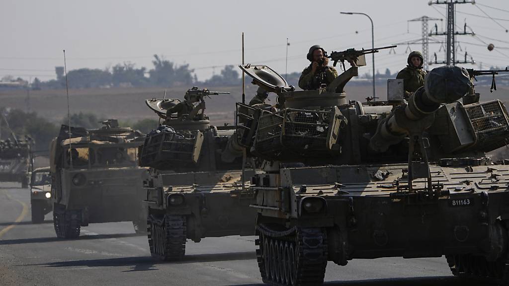 Israelische Soldaten bewegen sich mit gepanzerten Militärfahrzeugen im Süden Israels auf die Grenze zum Gazastreifen zu. Foto: Ariel Schalit/AP/dpa