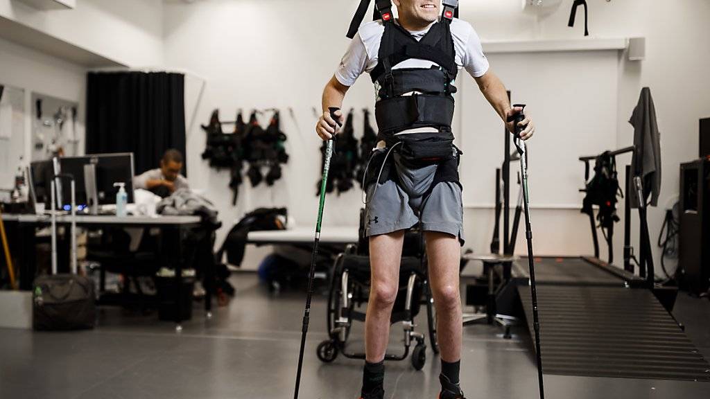 Der Schweizer Paraplegiker Sebastian Tobler kann dank Elektrostimulation, Training und mit Stützen wieder eigene Schritte tun.