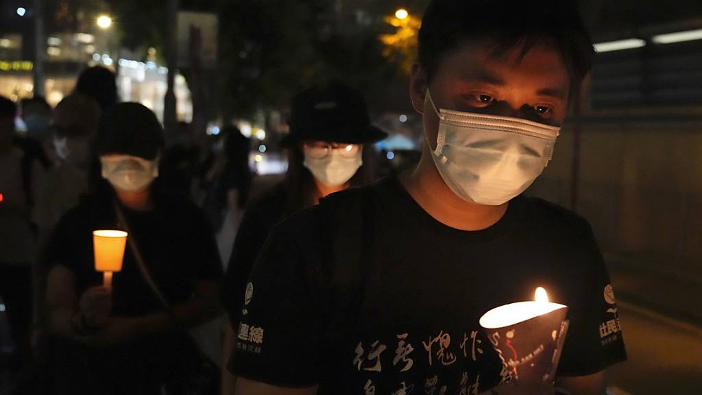 Menschen gehen mit Kerzen in den Händen vor dem Victoria Park entlang. Bereits in den vergangenen Jahren hatten sich dort etliche Menschen zum Jahrestag der blutigen Niederschlagung der Demokratiebewegung am 4. Juni 1989 in Peking versammelt.