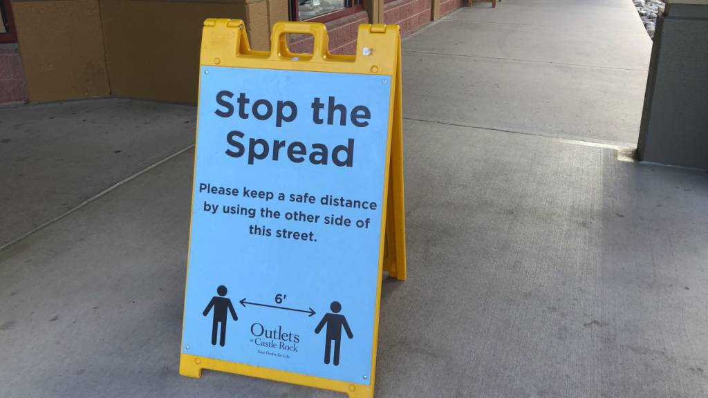Ein Schild vor einem Einkaufszentrum im US-Bundesstaat Colorado weist Kunden darauf hin, Abstand zu halten, um die Verbreitung des Coronavirus einzudämmen.