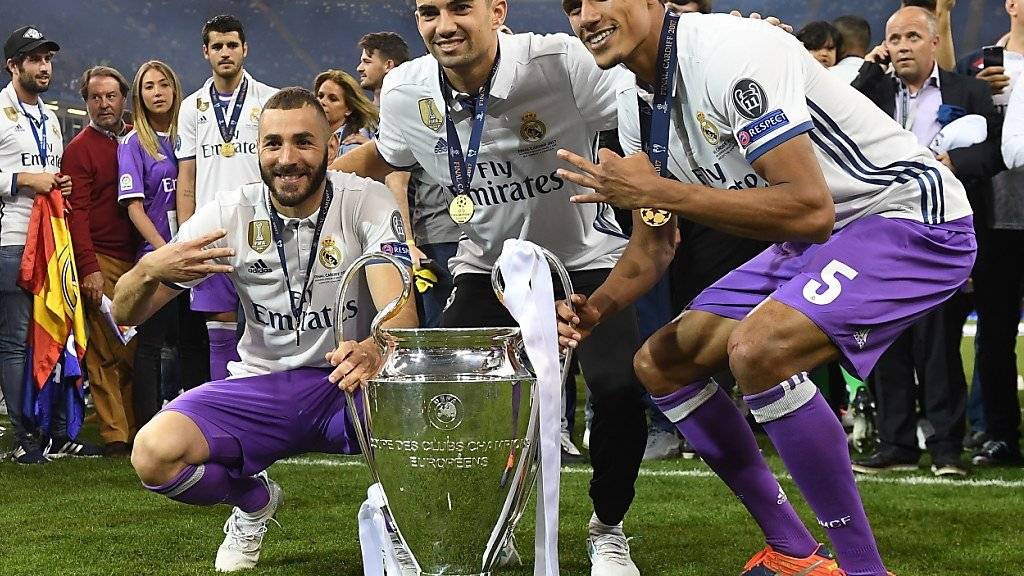 Enzo Zidane (Mitte) feiert mit Benzema (l.) und Varane den Champions-League-Titel mit Real Madrid.