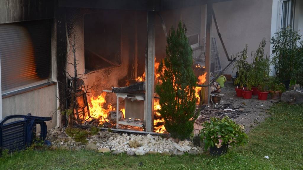 Ein Grill auf einer ebenerdigen Terrasse steh in Flammen. (Symbolbild)