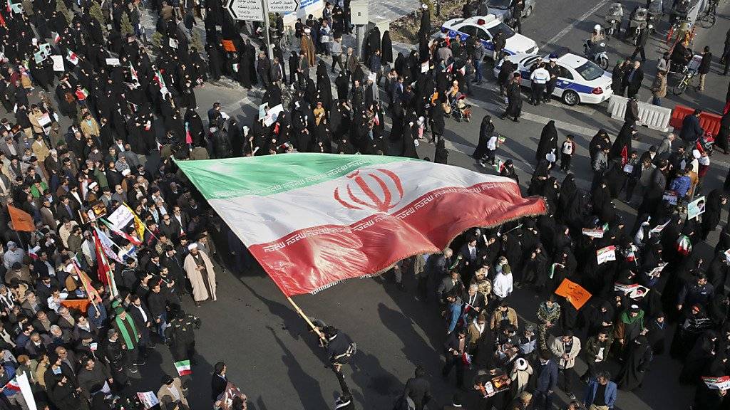 Pro-Regierungs-Demonstranten im nordostiranischen Maschhad schwenken die Nationalflagge.