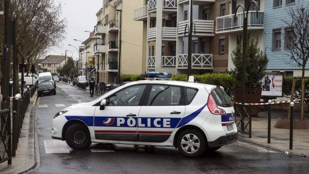 Ein Polizeiauto blockiert am Freitag die Strasse im nordwestlich von Paris liegenden Argenteuil, in der die Wohnungsdurchsuchung stattfand.