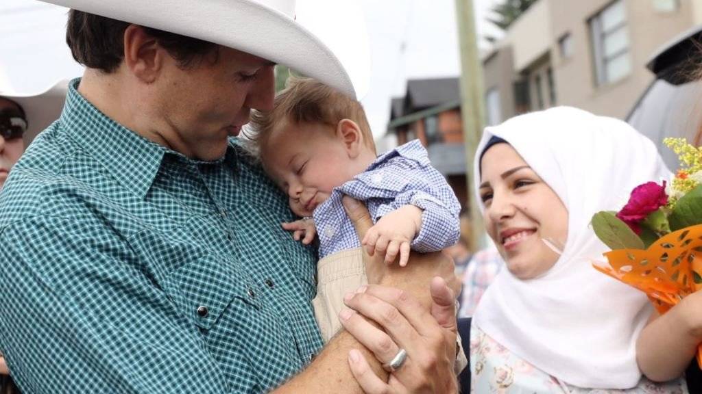 Kanadas Premierminister Justin Trudeau hält das nach ihm benannte Flüchtlingskind Justin-Trudeau Adam Bilal an einem Volksfest in Calgary auf dem Arm.