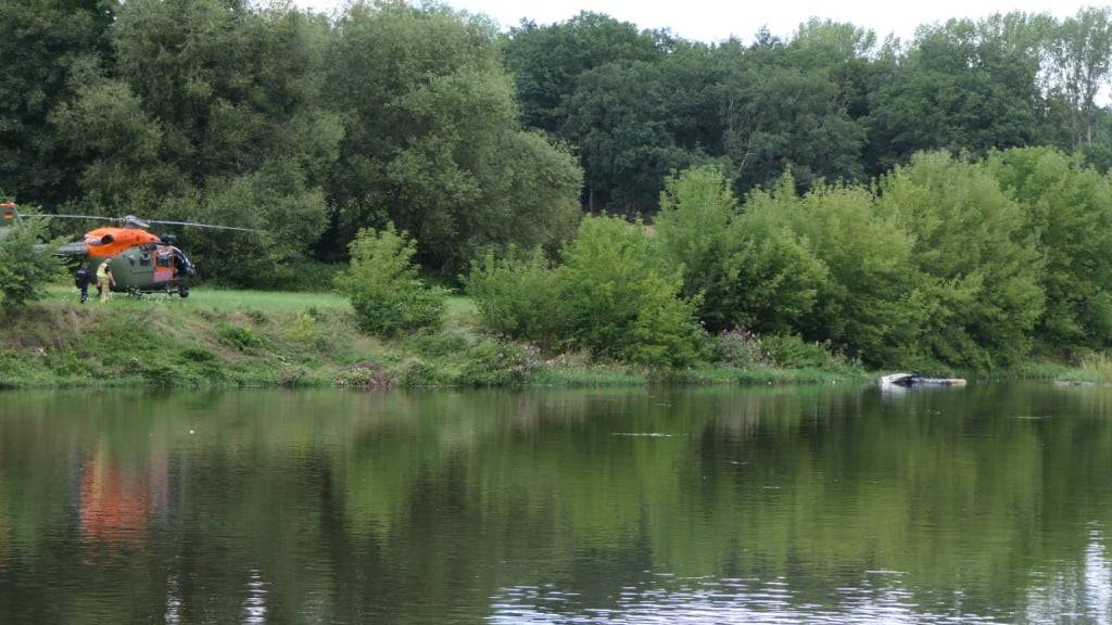 Ein Hubschrauberg (rechts) treibt in der Nähe von Grimma in Sachsen in einem Fluss. Ein Bundeswehr-Helikopter ist in der Nähe von Grimma in Sachsen in einen Fluss gestürzt. Foto: Sören Müller/Medienportal-Grimma/dpa
