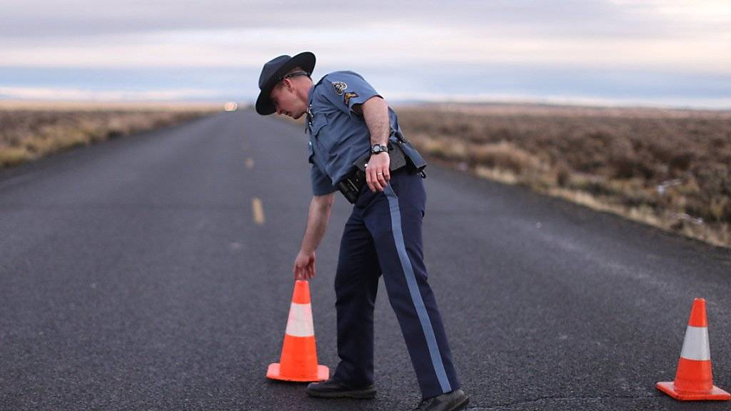Ein Polizist im US-Bundesstaat Oregon installiert eine Strassensperre beim Naturpark, der von einer Bürgerwehr besetzt wurde.