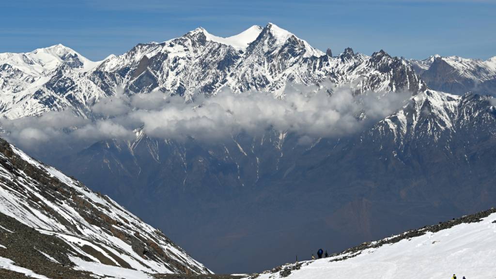 PRODUKTION - Schneebedeckte Berggipfel des Himalaya ragen über einer Wolkenschicht auf. Foto: Elisa Schu/dpa/Symbolbild
