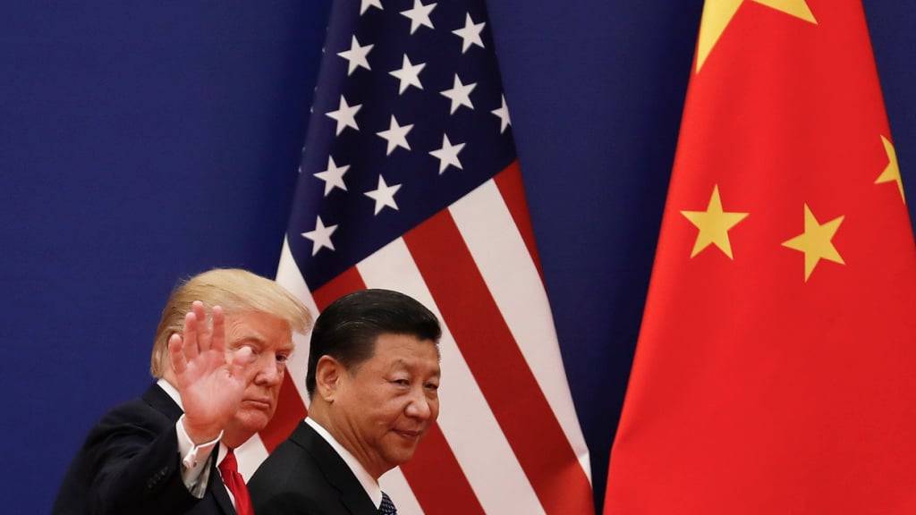 ARCHIV - Der chinesische Präsidenten Xi Jinping (r) geht in der Großen Halle des Volkes zusammen mit dem US-Präsidenten Donald Trump an Nationalflaggen vorbei. Nach der Wiederwahl Trumps zum US-Präsidenten gratulierte ihm Xi in einem Telefonat. Foto: Andy Wong/AP/dpa