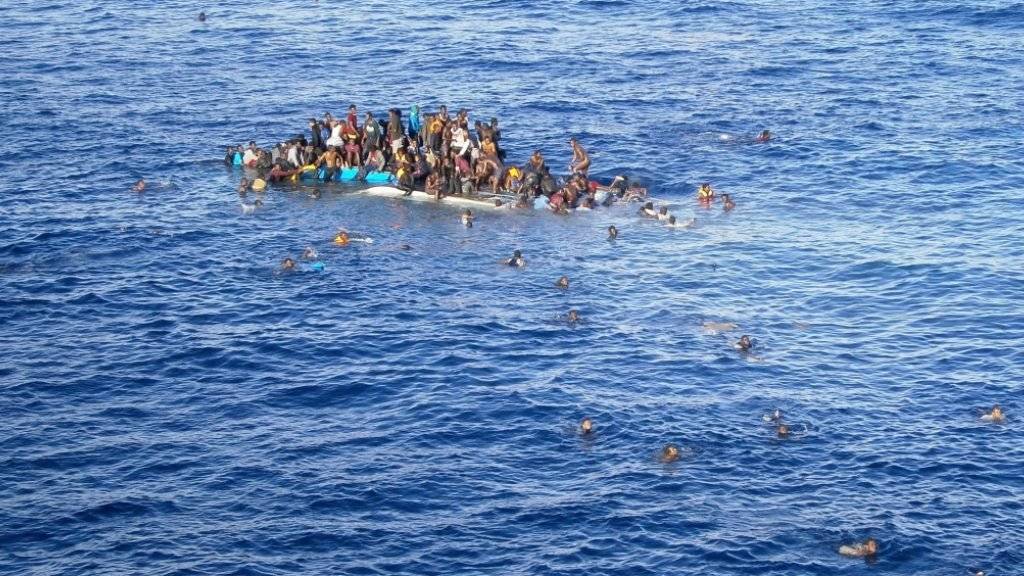Flüchtlinge auf einem sinkenden Boot im Mittelmeer.(Archivbild) Die spanische Marine rettete am Donnerstag 286 in Seenot geratene Menschen von einem nur 15 Meter langen Holzboot. Die meisten kamen aus Afrika.