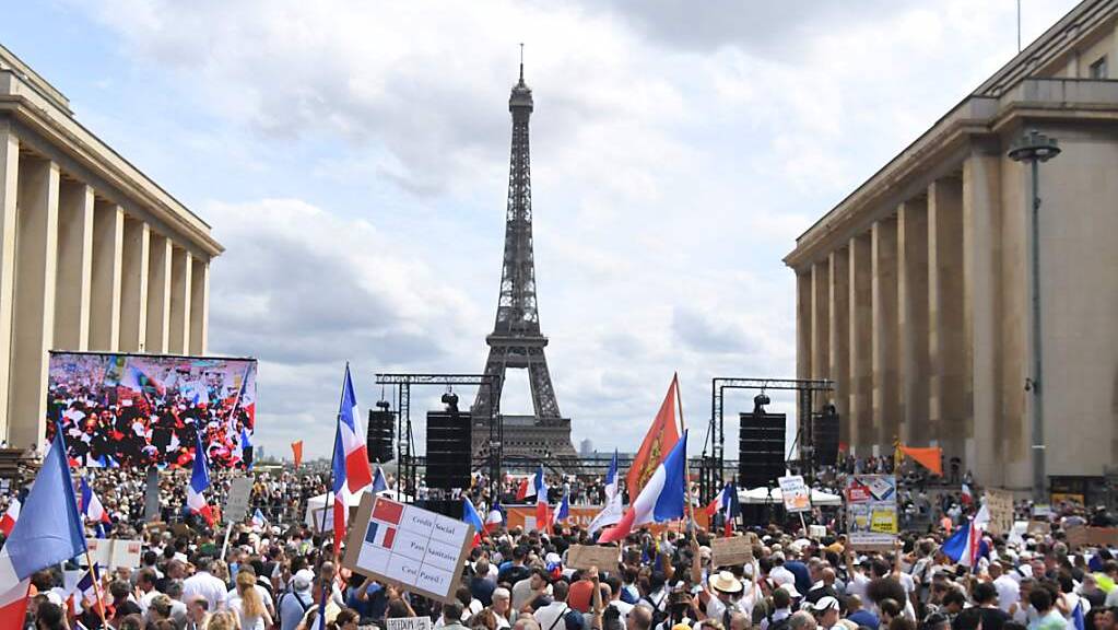 Demonstranten nehmen in Paris an einem Protest gegen die verschärften Corona-Regeln teil. Foto: Alain Jocard/AFP/dpa