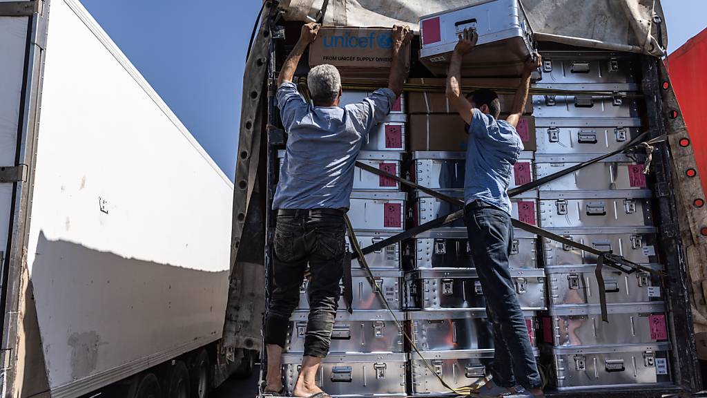 ARCHIV - Freiwillige Helfer entladen einen Lastwagen mit humanitären Hilfsgütern. Foto: Anas Alkharboutli/dpa/Archivbild