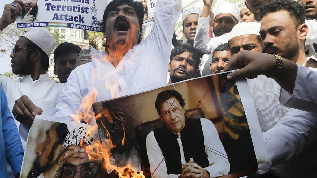 Indische Muslime wegen des Anschlags auf den paramilitärischen Konvoi in Kaschmir, der mindestens 40 Menschen getötet hatte. Sie verbrennen Plakate des pakistanischen Premierministers Imran Khan (Mitte).