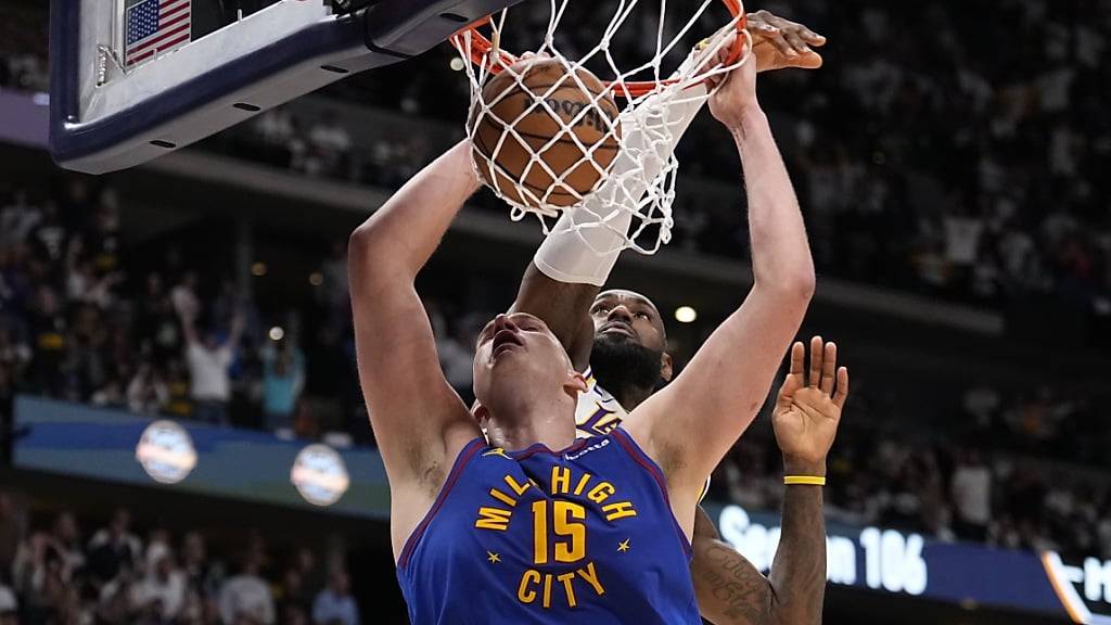 Denvers Topskorer Nikola Jokic beim Dunk, LeBron James von den Los Angeles Lakers kommt zu spät