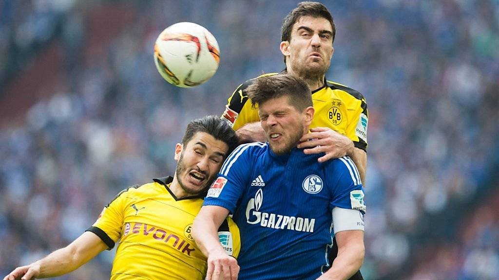 Schalkes Klaas-Jan Huntelaar (mitte) behauptet sich gleich gegen zwei Dortmunder (Nuri Sahin und Sokratis). Huntelaar erzielte nach 66 Minuten das Tor zum 2:2-Schlussstand