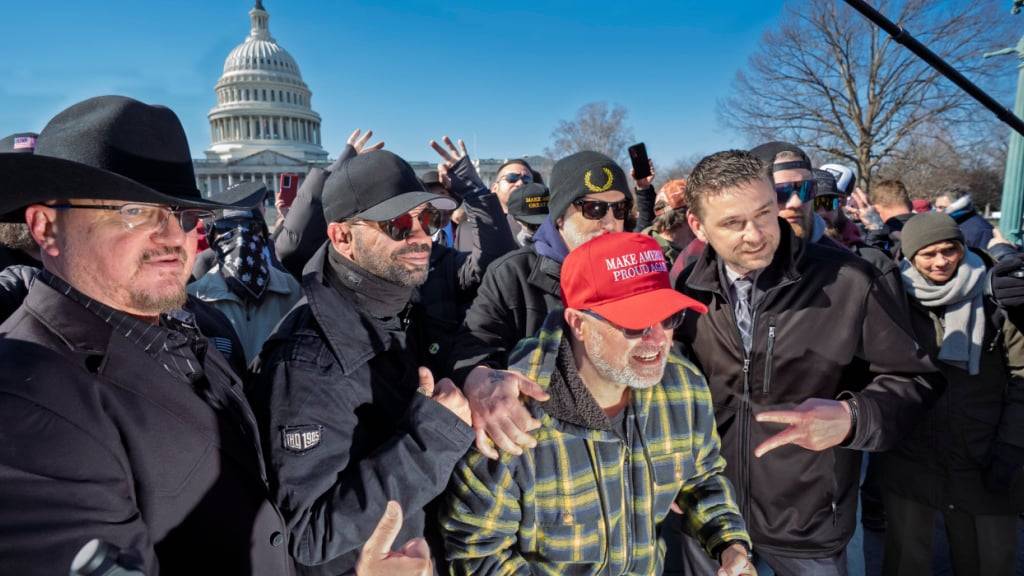 ARCHIV - «Proud Boys» posieren bei einer Pressekonferenz in der Nähe des US-Kapitols. Direkt zu Beginn seiner zweiten Amtszeit begnadigte US-Präsident Trump alle Beteiligten des Biggs und Zachary Rehl Kapitol-Sturms. (zu dpa: «Rechte Kapitolstürmer fordern Schadenersatz von US-Regierung») Foto: J. Scott Applewhite/AP/dpa