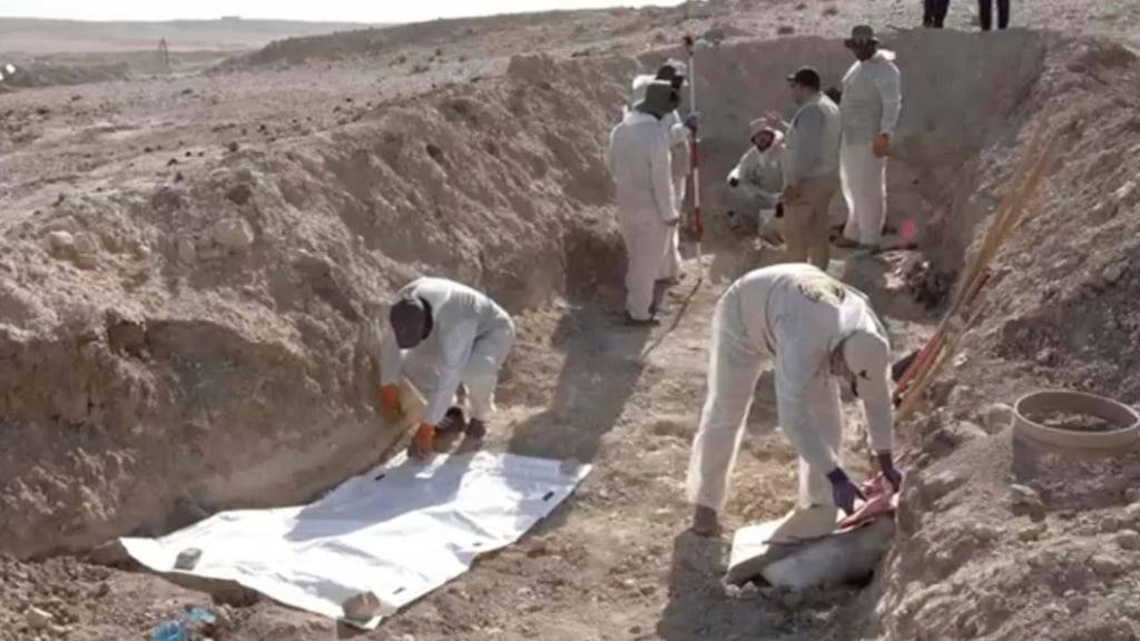 HANDOUT - Arbeiter graben menschliche Überreste in der Nähe der nordirakischen Stadt Mosul aus. Foto: Uncredited/Rudaw TV via AP/dpa - ACHTUNG: Nur zur redaktionellen Verwendung und nur mit vollständiger Nennung des vorstehenden Credits. Der Ausschnitt darf nicht verändert werden.