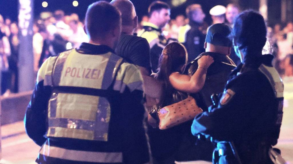 dpatopbilder - Ersthelfer und Polizisten tragen eine Verletze zu den Sanitätern auf einer Brücke. Ein Feuerwerkskörper explodierte in zu niedriger Höhe über Zuschauern beim Abschlussfeuerwerk der Rheinkirmes. Es gab mehrere Verletzte. Foto: David Young/dpa