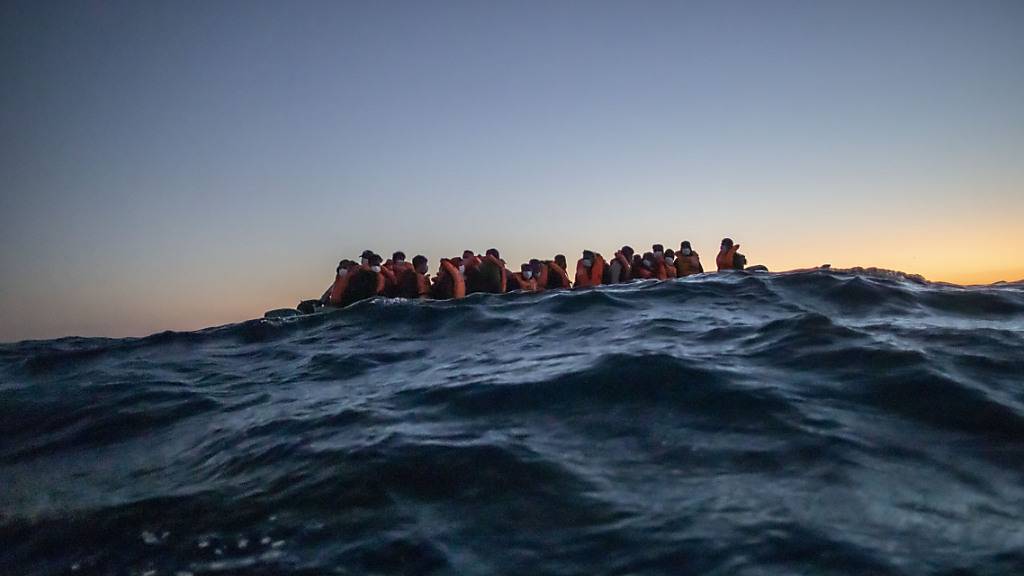 ARCHIV - Migranten aus verschiedenen afrikanischen Nationen auf einem Boot auf vor der libyschen Küste im Mittelmeer auf ihrem Weg nach Europa. Foto: Bruno Thevenin/AP/dpa