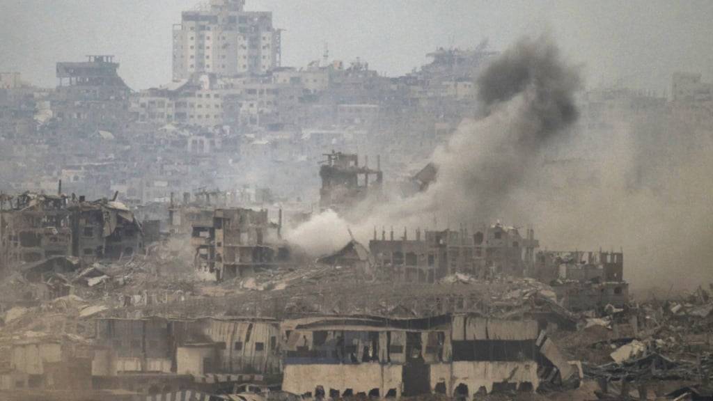 Rauch steigt inmitten zerstörter Gebäude nach einem israelischen Beschuss im Gazastreifen auf, gesehen vom Süden Israels aus. Foto: Leo Correa/AP/dpa