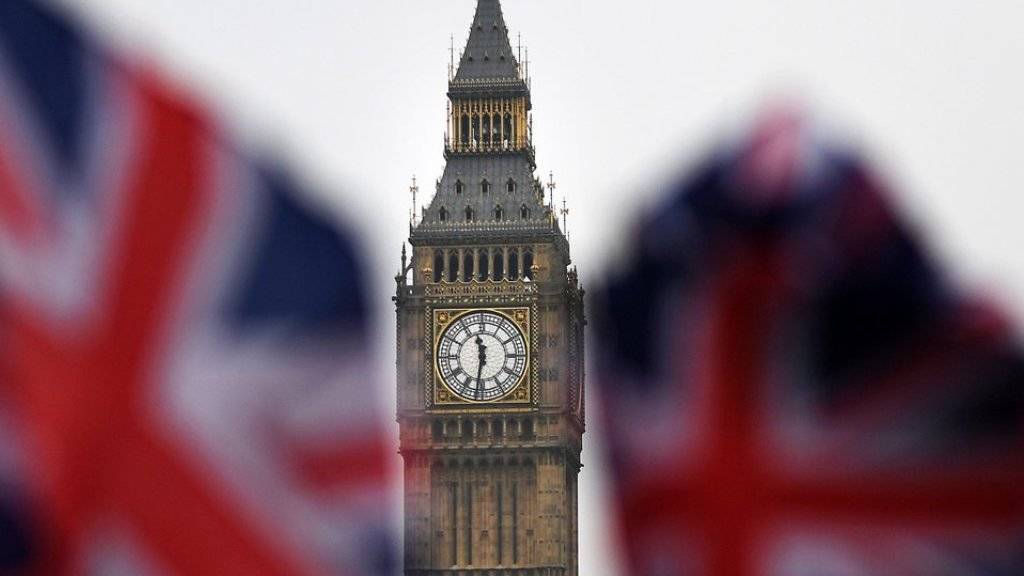 Blick zwischen zwei Union Jacks hindurch auf den Londoner Big Ben. Im Unterhaus begannen am Dienstag die Beratungen über ein Gesetz, das Premierministerin May das Recht einräumen soll, den Abschied nach Artikel 50 der EU-Verträge zu verkünden. (Archiv)