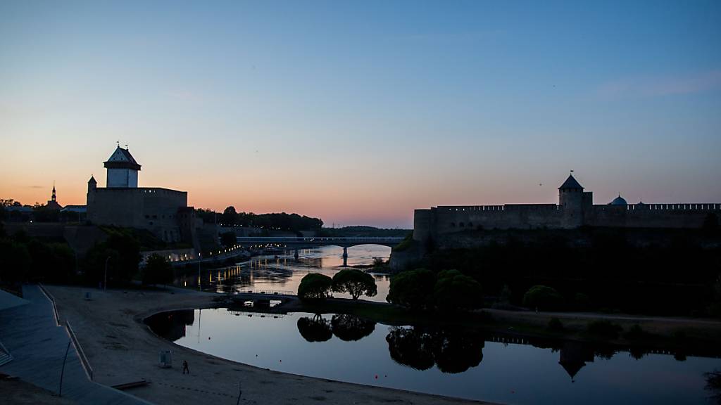 ARCHIV - Die Sonne geht hinter in der estnischen Stadt Narva und der russischen Burg Iwangorod unter. Foto: Kay Nietfeld/dpa
