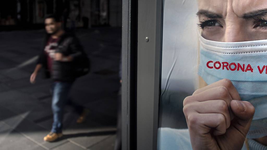Ein Mann spaziert an einem Werbeplakat gegen das Coronavirus in Wien vorbei. (Archivbild)
