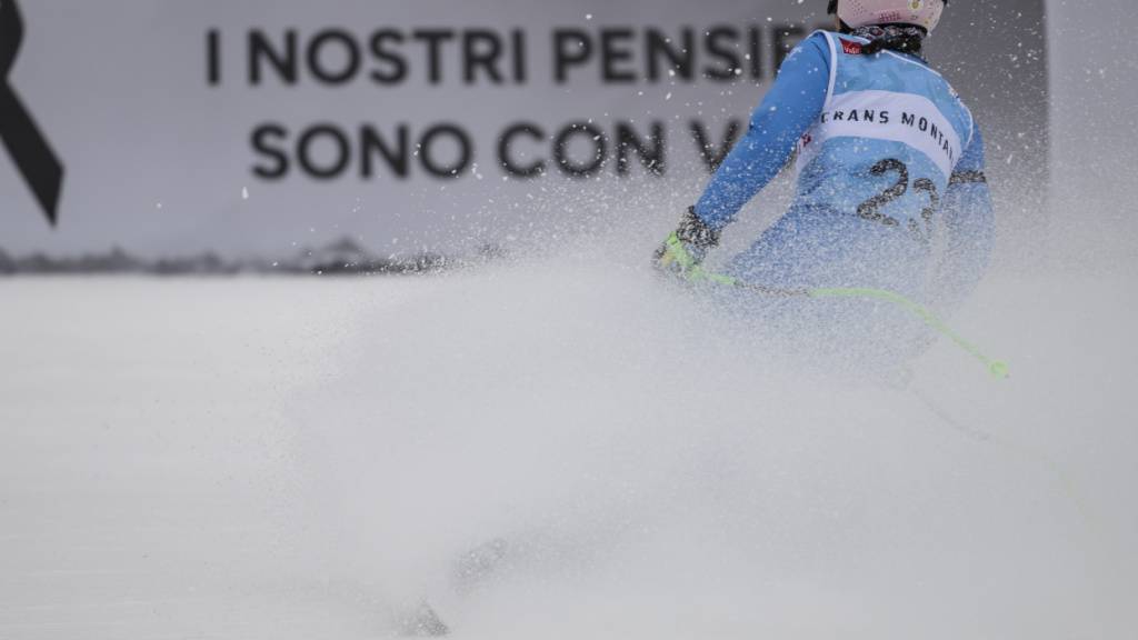 Die Italienerin Elena Curtoni schwingt im Zielraum in Crans-Montana vor der Werbebande mit der Aufschrift «Unsere Gedanken sind bei euch» ab