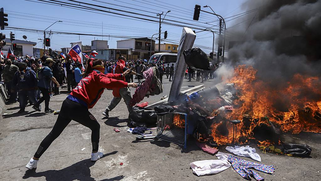 Menschen verbrennen Zelte und Gegenstände venezolanischer und kolumbianischer Migranten während einer Demonstration gegen illegale Einwanderung. Foto: Ignacio Muñoz/AP/dpa