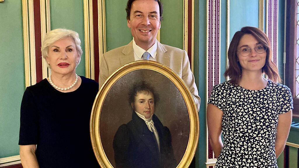 Der Sittener Stadtpräsident Philippe Varone (Mitte) mit dem wieder aufgefundenen Gemälde, flankiert von der Besitzerin Emmanuelle de Kalbermatten (links) und der Stadtarchivarin Coline Remy (r.).