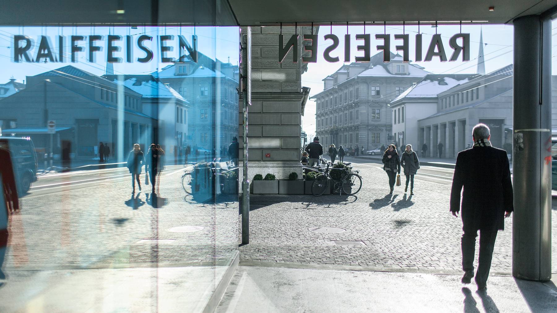 Passanten vor der Bank Raiffeisen am Limmatquai in Zürich.