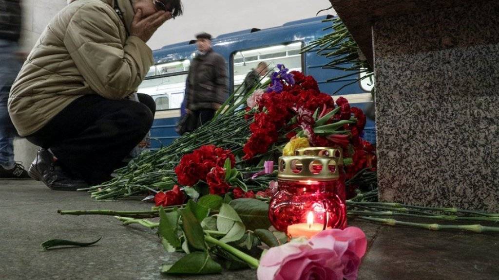 Eine Frau kniet in der St. Petersburger U-Bahn-Station «Tekhnologichesky Institut» vor im Gedenken an die Opfer des Anschlags niedergelegten Blumen.
