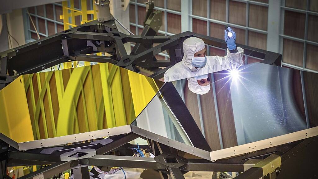 In diesem von der NASA zur Verfügung gestellten Foto vom 29. September 2014 untersucht der Optikingenieur Larkin Carey zwei Testspiegelsegmente an einem Prototyp. Die US-Raumfahrtbehörde Nasa teilte mit, dass sich der Start des neuen Weltraumteleskops «James Webb» ins All erneut verzögert. Foto: Chris Gunn/NASA via AP/dpa