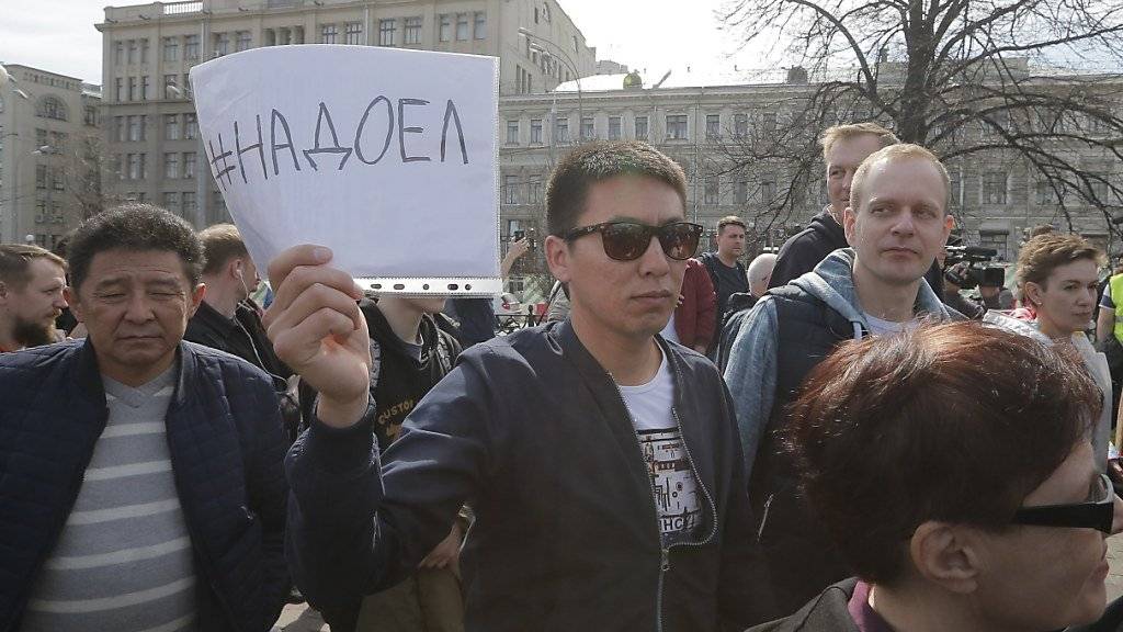 Anti-Putin-Demonstranten im Zentrum Moskaus halten Transparente mit der Aufschrift «Nadojel» hoch - deutsch etwa: «Wir haben genug/Wir sind es leid».