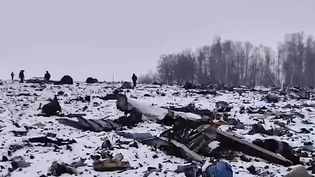 HANDOUT - Ein Mitarbeiter des Russischen Ermittlungskomitees geht durch ein Gebiet, in dem Wrackteile der russischen Militärmaschine Il-76 abgestürzt sind. Foto: Uncredited/Russian Investigative Committee/AP/dpa - ACHTUNG: Nur zur redaktionellen Verwendung und nur mit vollständiger Nennung des vorstehenden Credits