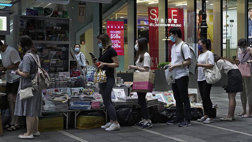 Menschen stehen an einem Zeitungsstand Schlange, um Exemplare der Zeitung «Apple Daily» zu kaufen.