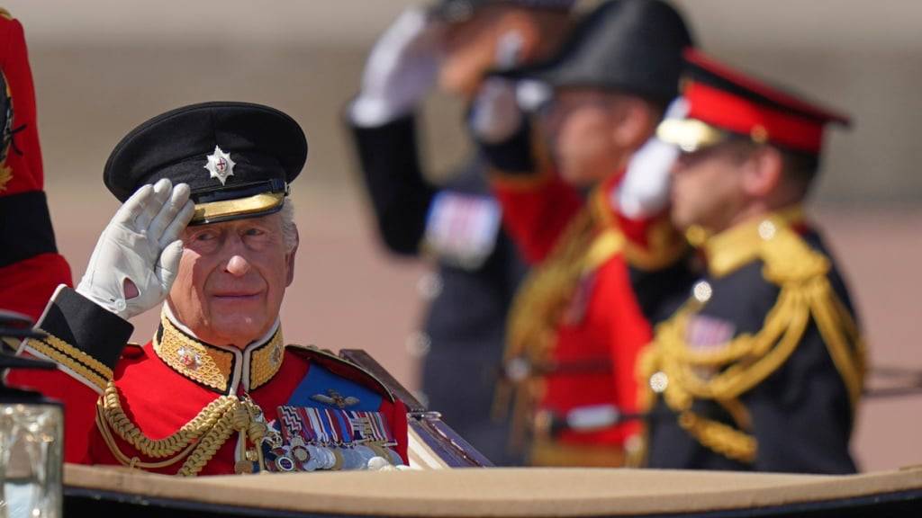 Großbritanniens König Charles III salutiert, während er in einer Kutsche die Mall entlangfährt, um am Trooping the Colour in London teilzunehmen. Foto: Alberto Pezzali/AP/dpa