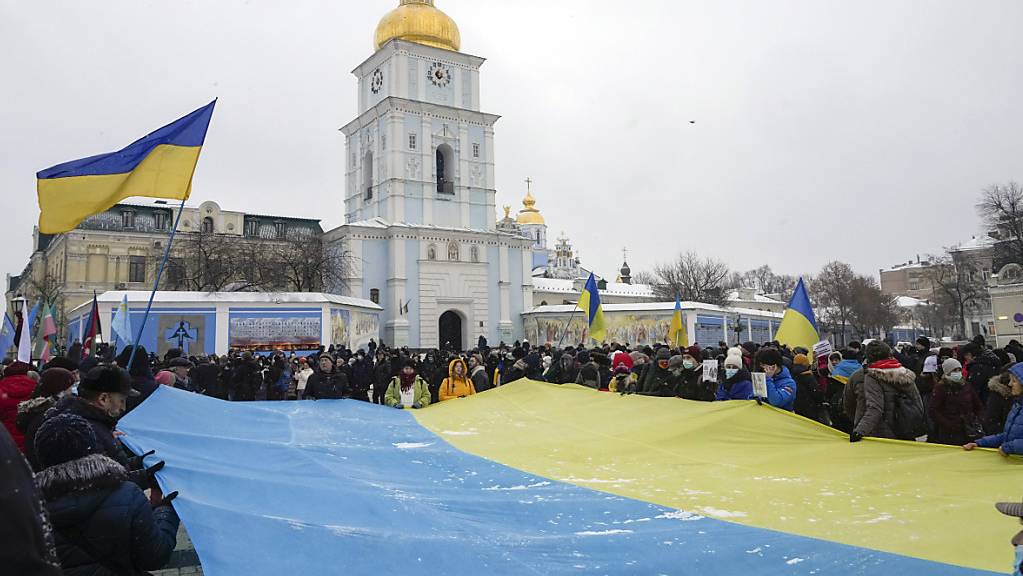 Aktivisten Aktivisten zeigen eine riesige ukrainische Nationalflagge während einer «Say-NO-to-Putin»-Kundgebung in der Nähe der St. Michael-Kathedrale. Foto: Efrem Lukatsky/AP/dpa