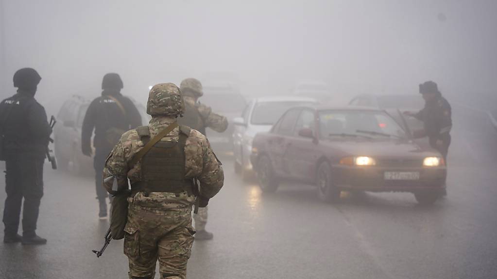 Bewaffnete kasachische Soldaten stehen auf einer Strasse und kontrollieren Autos. Durch die Unruhen wurden mehr Menschen verletzt oder getötet als ursprünglich angenommen.